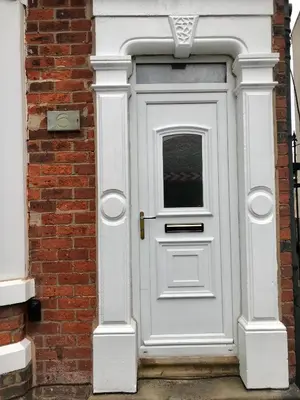a white door on the side of a brick building at 3 Bedroom House Close to M6 & M55 in Preston