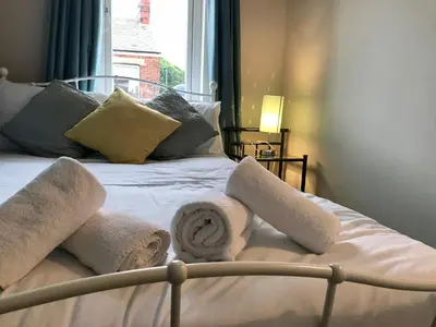 a bed with towels on it with a window at 3 Bedroom House Close to M6 & M55 in Preston