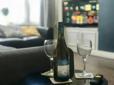 a bottle of wine and two glasses on a table at 3 Bedroom House Close to M6 & M55 in Preston