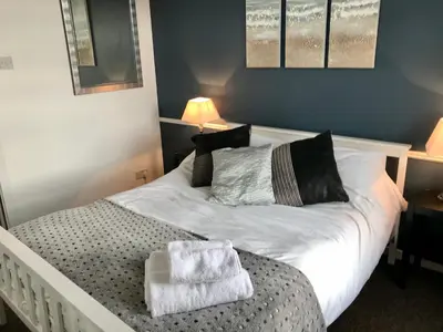 a bedroom with a bed with two towels on it at 3 Bedroom House Close to M6 & M55 in Preston