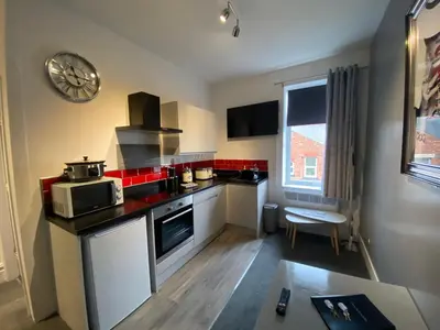 a small kitchen with a stove and a microwave at Blackpool Abode - 124 Elite Apartments in Blackpool