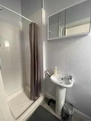 a white bathroom with a sink and a shower at Blackpool Abode - 124 Elite Apartments in Blackpool