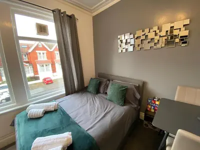 a small bedroom with a bed and a window at Blackpool Abode - 124 Elite Apartments in Blackpool