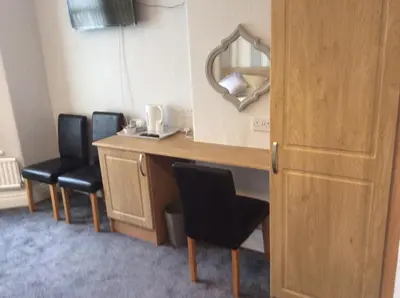 a room with a desk with two chairs and a mirror at Beaucliffe continental in Blackpool
