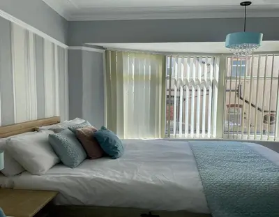a bedroom with a large bed with pillows and a window at Beaucliffe continental in Blackpool