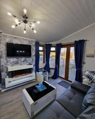 a living room with a couch and a fireplace at 4 Bed Luxury Lodge with Hot tub near Lake District in Warton