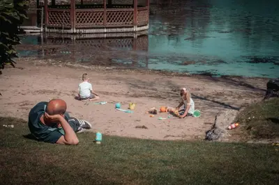 a group of people playing in the sand near the water at 4 Bed Luxury Lodge with Hot tub near Lake District in Warton