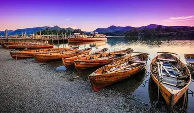 a group of boats sitting on the shore of a lake at 4 Bed Luxury Lodge with Hot tub near Lake District in Warton