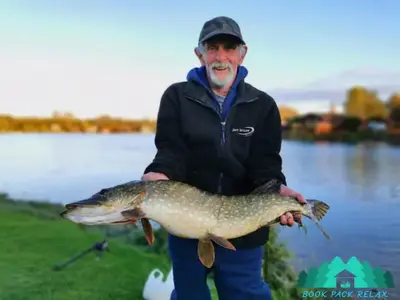 a man holding a fish in his hands at 4 Bed Luxury Lodge with Hot tub near Lake District in Warton