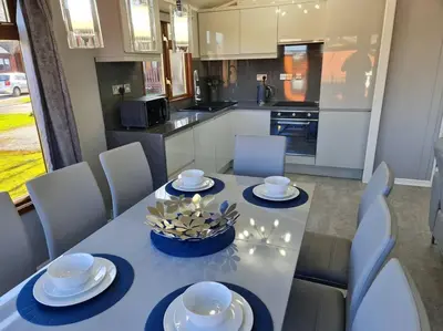 a dining room table with a blue table cloth and chairs at 4 Bed Luxury Lodge with Hot tub near Lake District in Warton
