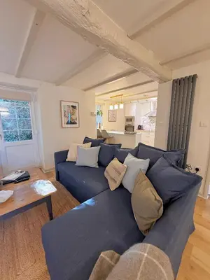 a living room with a blue couch and a table at Little Wren Cartmel Couples Retreat in Cartmel
