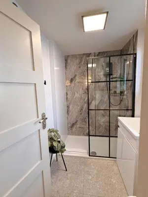 a bathroom with a shower with a glass door at Little Wren Cartmel Couples Retreat in Cartmel