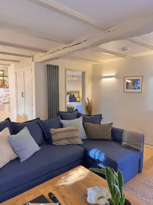 a blue couch with pillows in a living room at Little Wren Cartmel Couples Retreat in Cartmel