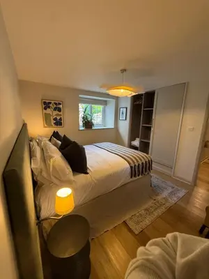 a bedroom with a large bed and a window at Little Wren Cartmel Couples Retreat in Cartmel