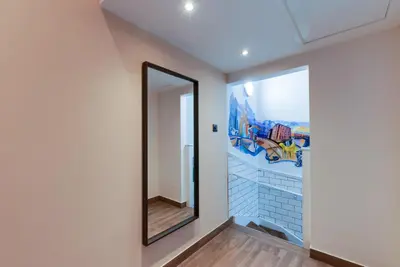 a hallway with a mirror and a mural on the wall at Alberts Apartments in Liverpool