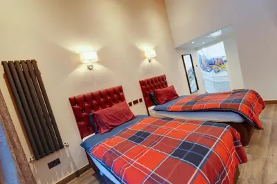 a bedroom with two beds and a radiator at Alberts Apartments in Liverpool