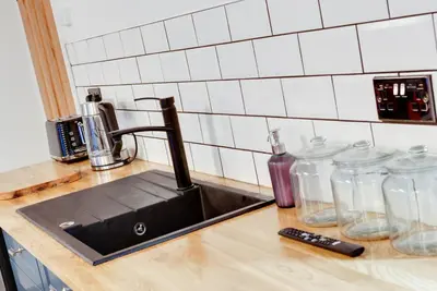 a kitchen counter with a sink and glass jars at Alberts Apartments in Liverpool
