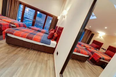 a bedroom with two beds and a mirror at Alberts Apartments in Liverpool