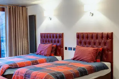 two beds sitting next to each other in a room at Alberts Apartments in Liverpool