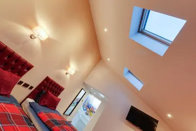 a bedroom with a red bed and a window at Alberts Apartments in Liverpool