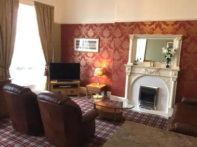a living room with a fireplace and a television at Eden Vale First Floor Sea View Apartment in Morecambe