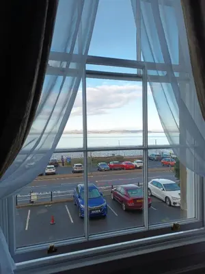 a window with cars parked in a parking lot at Eden Vale First Floor Sea View Apartment in Morecambe
