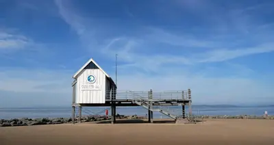 a life guard shack on a beach with the ocean at Eden Vale First Floor Sea View Apartment in Morecambe