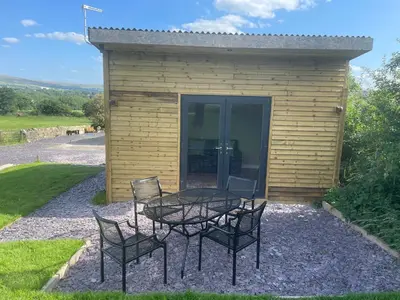a table and chairs in front of a building at Beautiful self-catering cottages, Ribble Valley in West Bradford