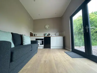 a living room with a couch and a kitchen at Beautiful self-catering cottages, Ribble Valley in West Bradford