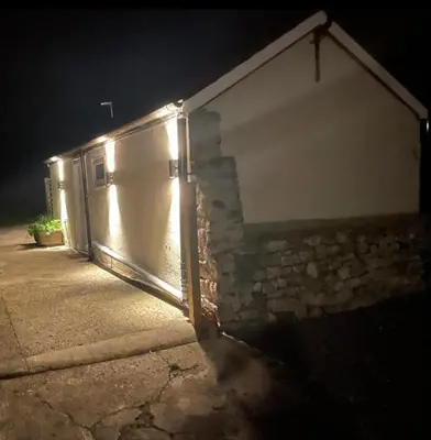 a garage door with lights on it at night at Beautiful self-catering cottages, Ribble Valley in West Bradford