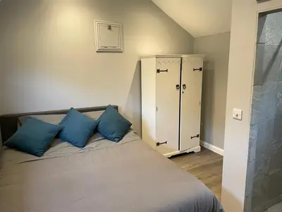 a bedroom with a bed with blue pillows on it at Beautiful self-catering cottages, Ribble Valley in West Bradford