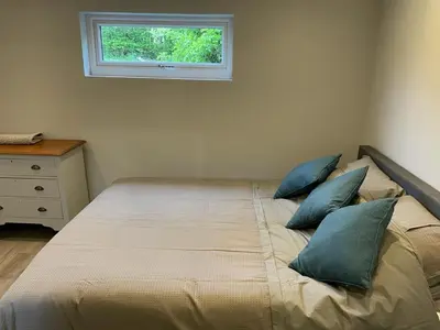a bed with blue pillows in a bedroom with a window at Beautiful self-catering cottages, Ribble Valley in West Bradford