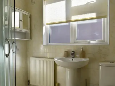 a bathroom with a sink and a window and a toilet at Marrion House in Middleton