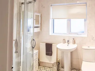 a bathroom with a toilet sink and a shower at Marrion House in Middleton