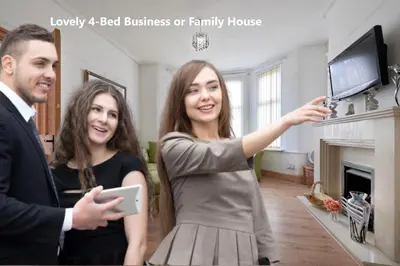 a man and woman standing in a living room holding a tablet at Contractors and Pets Welcome, Only 2 miles from M57, M58, Whole House Rental Sleeps 4 to 9, Short Walk to Orrell Station in Liverpool