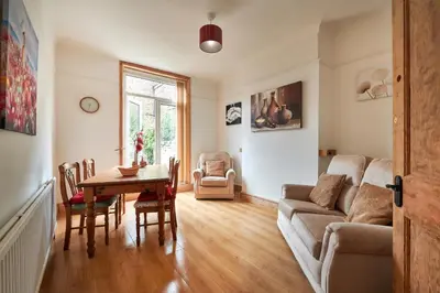 a living room with a table and a couch at Contractors and Pets Welcome, Only 2 miles from M57, M58, Whole House Rental Sleeps 4 to 9, Short Walk to Orrell Station in Liverpool