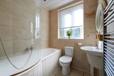 a bathroom with a tub and a toilet and a sink at Contractors and Pets Welcome, Only 2 miles from M57, M58, Whole House Rental Sleeps 4 to 9, Short Walk to Orrell Station in Liverpool