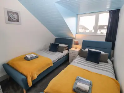 a attic bedroom with two beds and a window at Harbour View in Millom