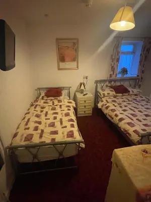 a bedroom with two beds and a television in it at Highbury Hotel in Blackpool