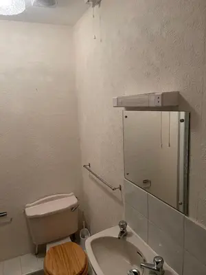 a bathroom with a toilet and a sink and a mirror at Highbury Hotel in Blackpool