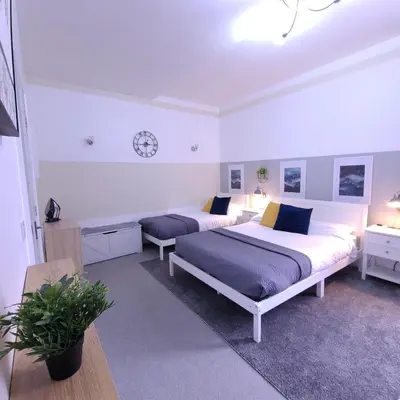 a bedroom with two beds and a clock on the wall at InstaLet Apartments I Wigan Central I Free Parking in Wigan