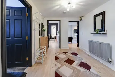 a hallway with a blue door and a rug at InstaLet Apartments I Wigan Central I Free Parking in Wigan