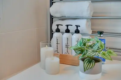 a bathroom counter with three candles and a potted plant at InstaLet Apartments I Wigan Central I Free Parking in Wigan