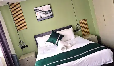 a bedroom with a bed with green and white pillows at Hotel 105 in Liverpool