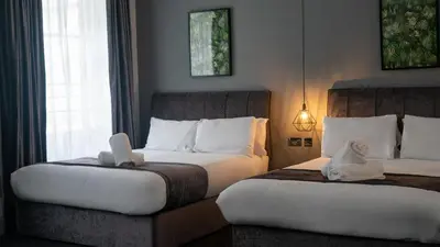 two beds in a hotel room with stuffed animals on them at Hotel 105 in Liverpool