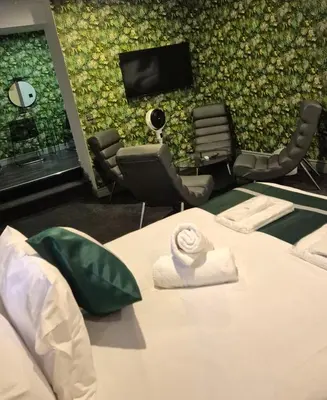 a room with a bed and a wall with a tv at Hotel 105 in Liverpool