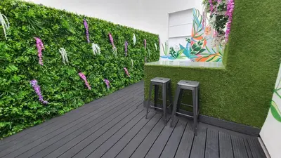 a patio with two stools next to a green hedge at Hotel 105 in Liverpool