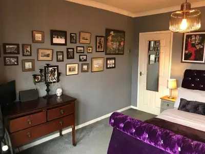 a bedroom with a purple bed and pictures on the wall at The Beach House South - Blackpool - Entire Holiday Home in Blackpool