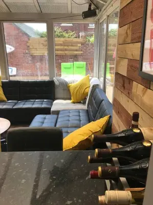 a living room with a couch and wine bottles at The Beach House South - Blackpool - Entire Holiday Home in Blackpool