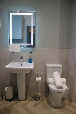 a bathroom with a sink and a toilet and a mirror at No 9 The Folly in Southport